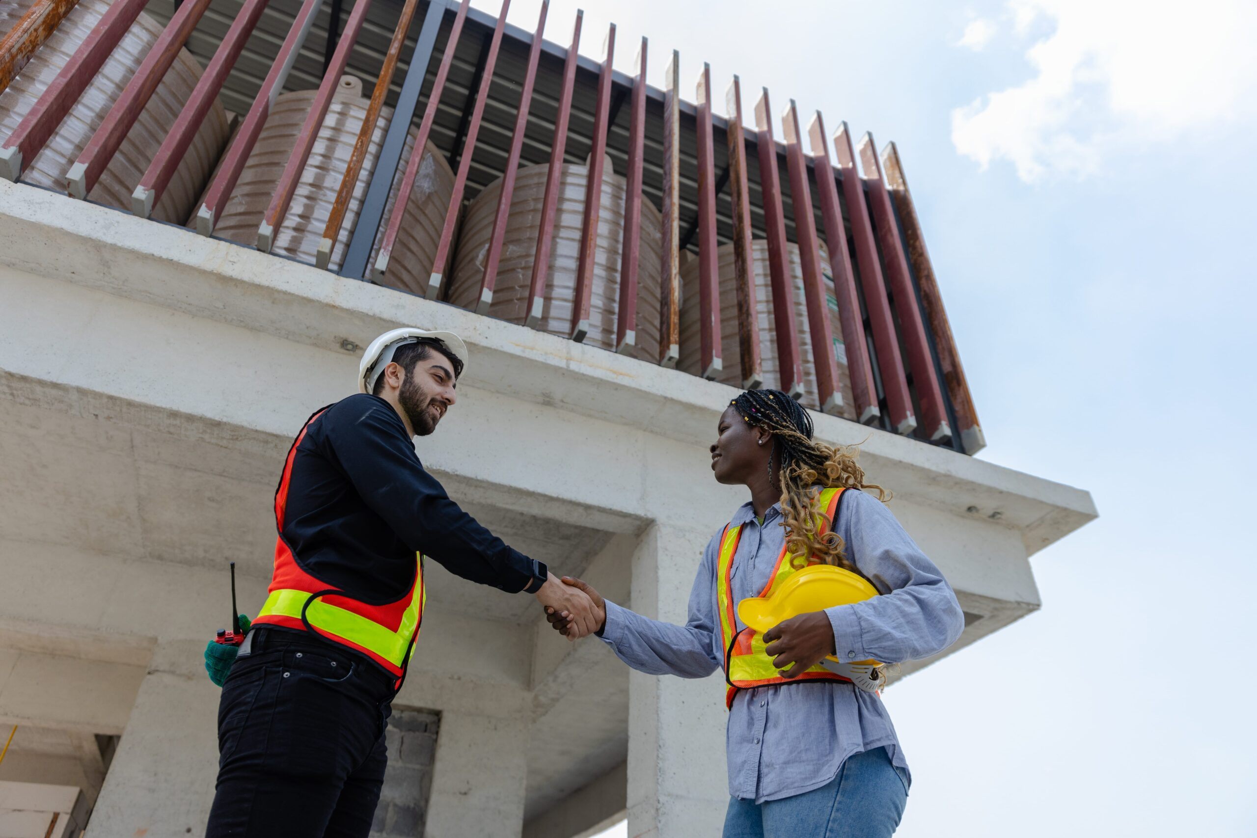 Two construction workers shaking hands at a construction site